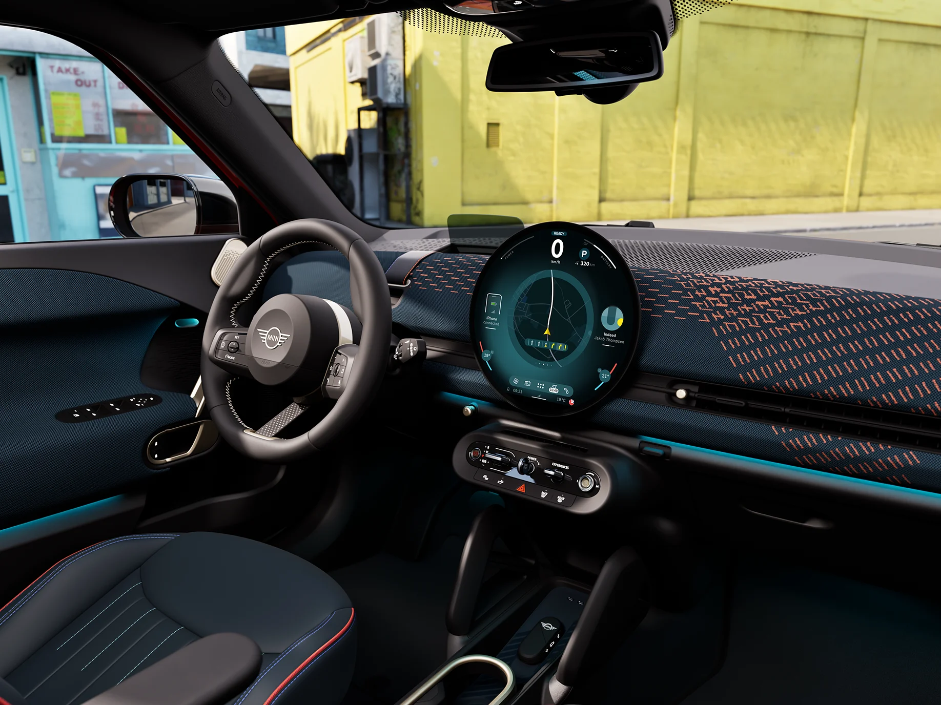 Interior view of the all-electric MINI Aceman with focus on the dashboard, the interaction unit and the steering wheel.